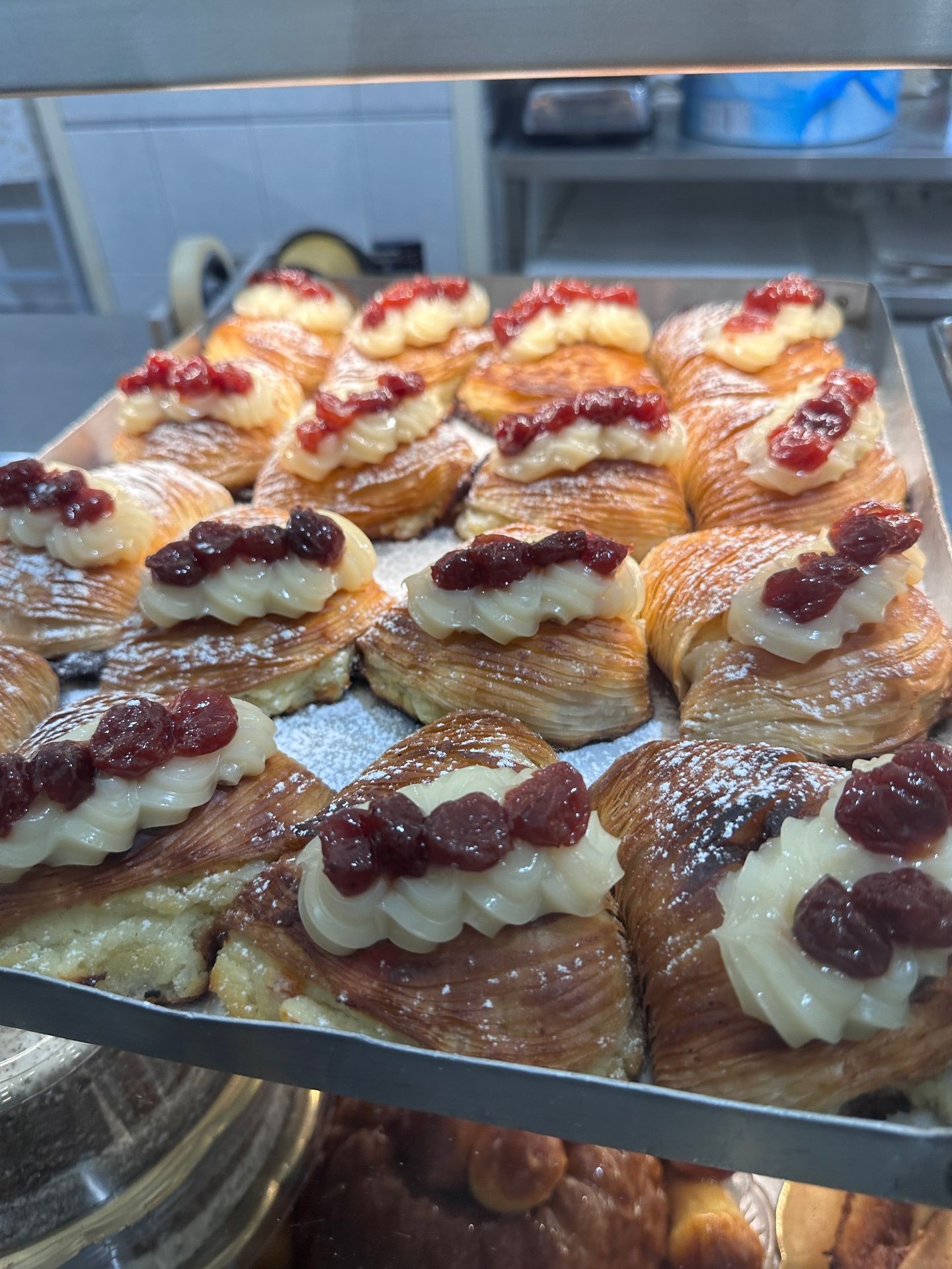 Pastries with cream and cherry topping displayed on a tray.