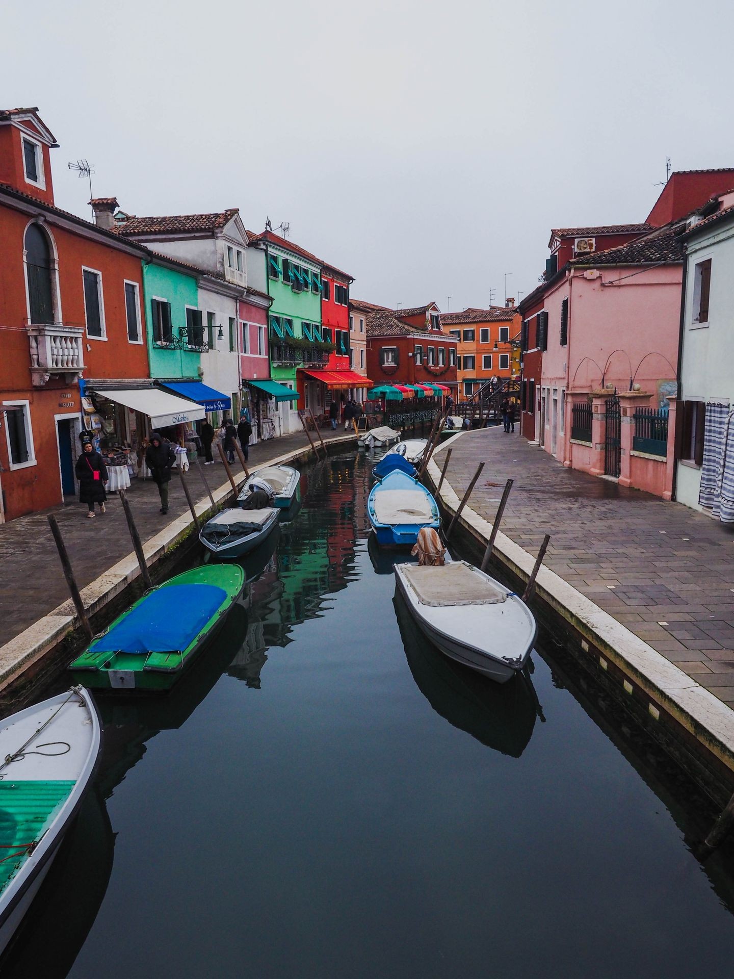 Canal with boats and colorful buildings on Burano, Italy.